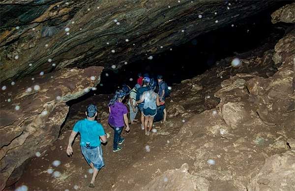 Cave explorers walking through narrow passages to Nil Diya Pokuna