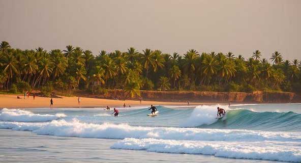 Surfers riding waves at Main Point in Arugam Bay Sri Lanka